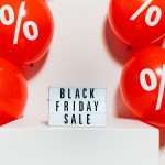 Red sales balloons around sign promoting Black Friday